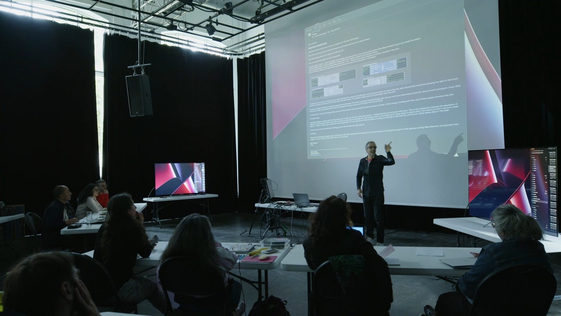 Événement hybride diffusé — grand écran de projection et public en salle lors d'une production Studio SIT